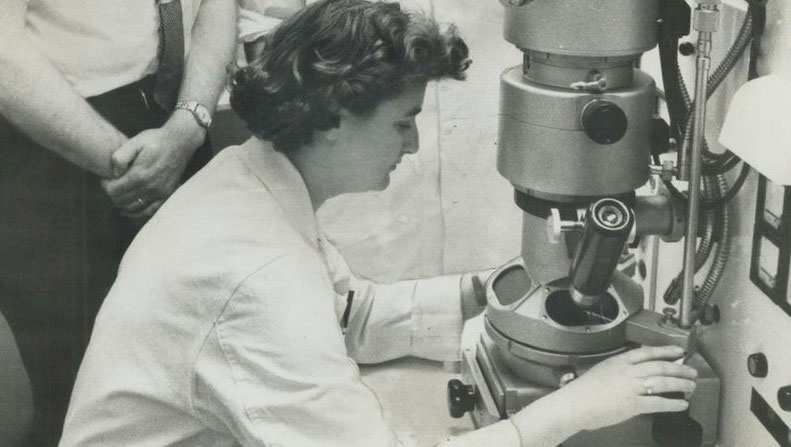 June Almeida observando a través de un microscopio