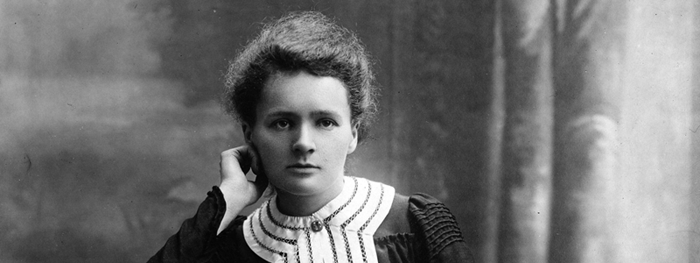 Primer plano de Marie Curie apoyando su cabeza sobre su mano.