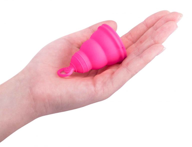 mano con copa menstrual rosa